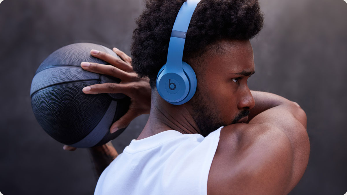 Man holding basketball wearing Solo 4 headphones