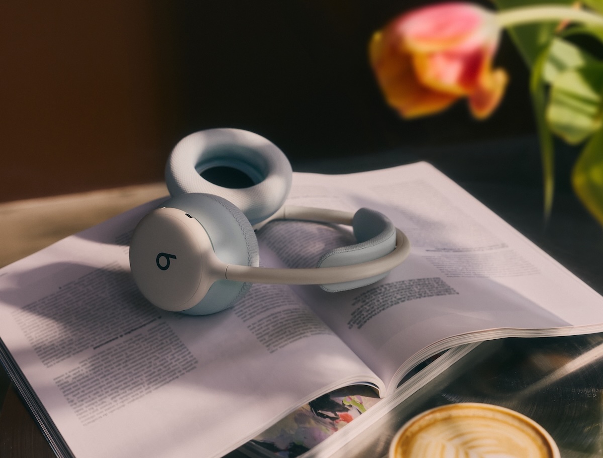 Beats 360 headphones in Cloud color with Sky color cushions resting on an open book