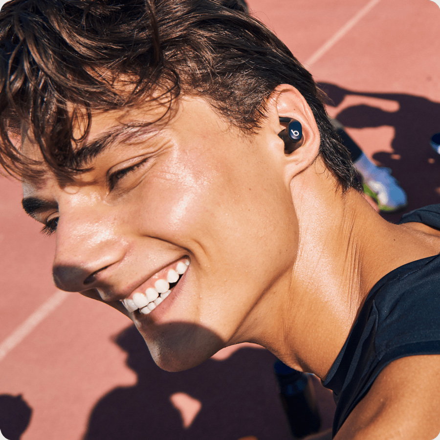 Person wearing the Powerbeats Fit earbuds demonstrating their sweat and water resistance