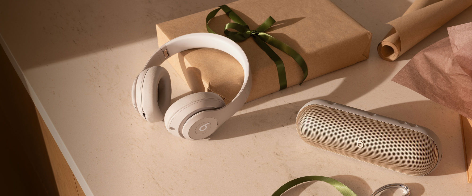 Beats headphones shown next to gift boxes and wrapping paper.