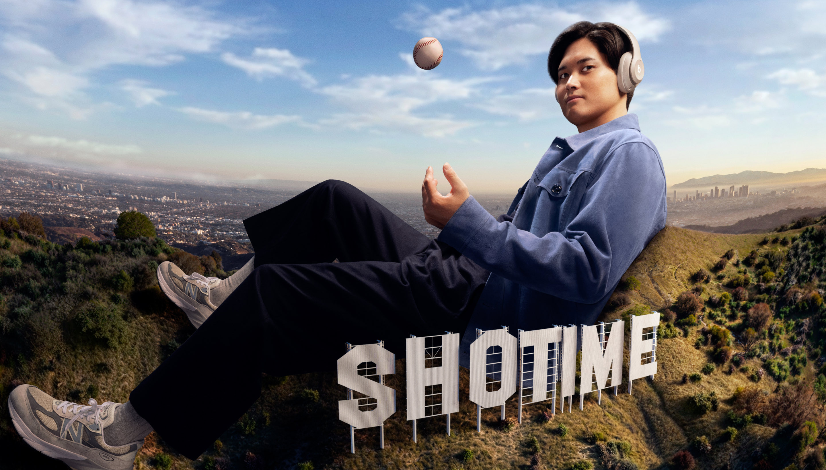 Beats Studio Proのヘッドフォンを着けた野球選手·大谷翔平が、丘の上に座り、手の上に野球ボールが浮かんでいる。丘には大きく「SHOTIME」の文字があり、背景にはロサンゼルスの都市風景が広がっている。