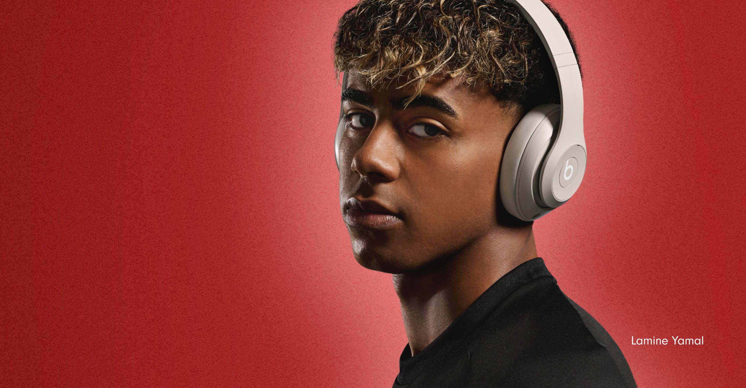 Footballer Lamine Yamal wearing Beats Studio Pro headphones in Sandstone against a bold red background, with the Spanish text "Nacido Para Esto" meaning "Born For This."