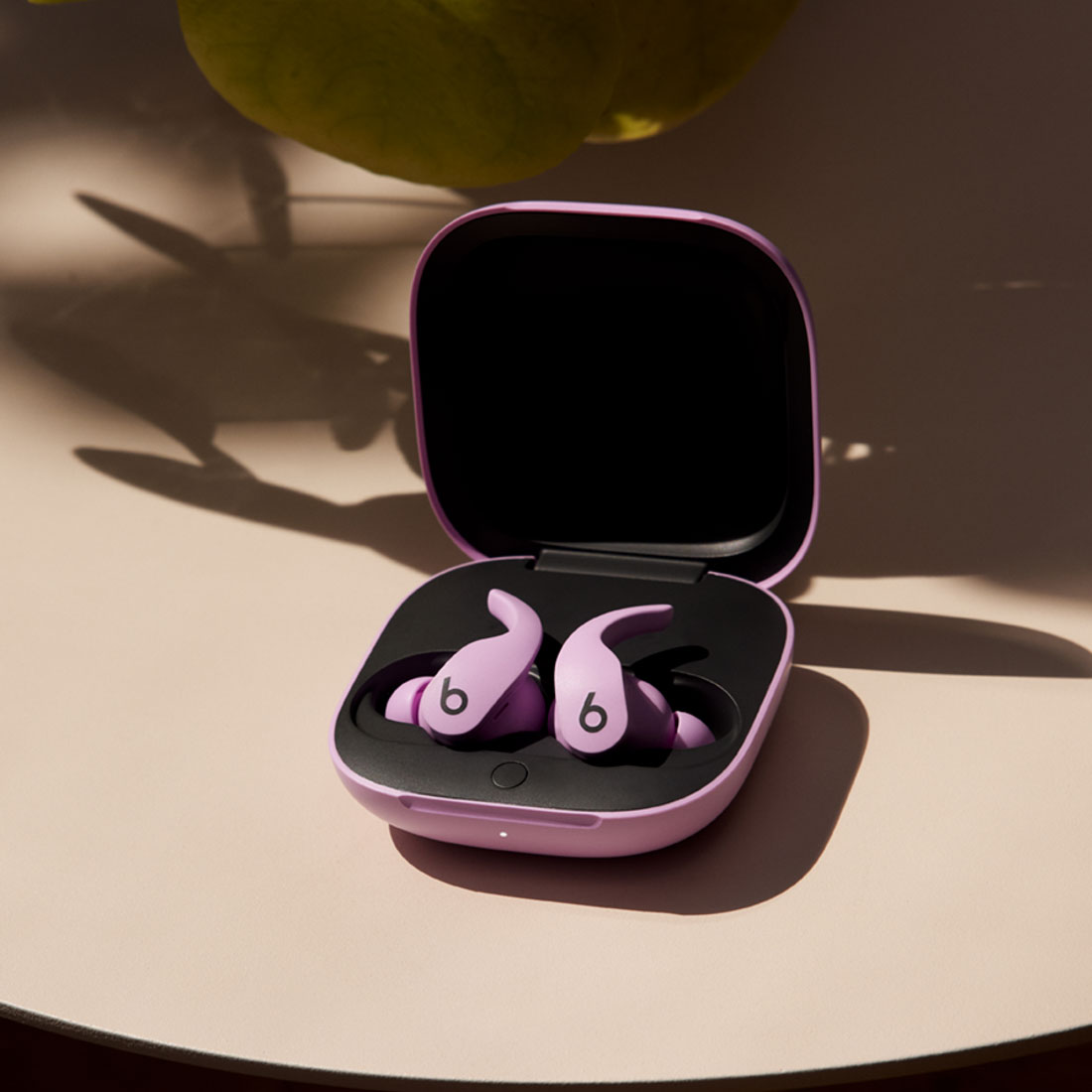 Beats Fit Pro earbuds and matching charging case in Stone Purple on a table.