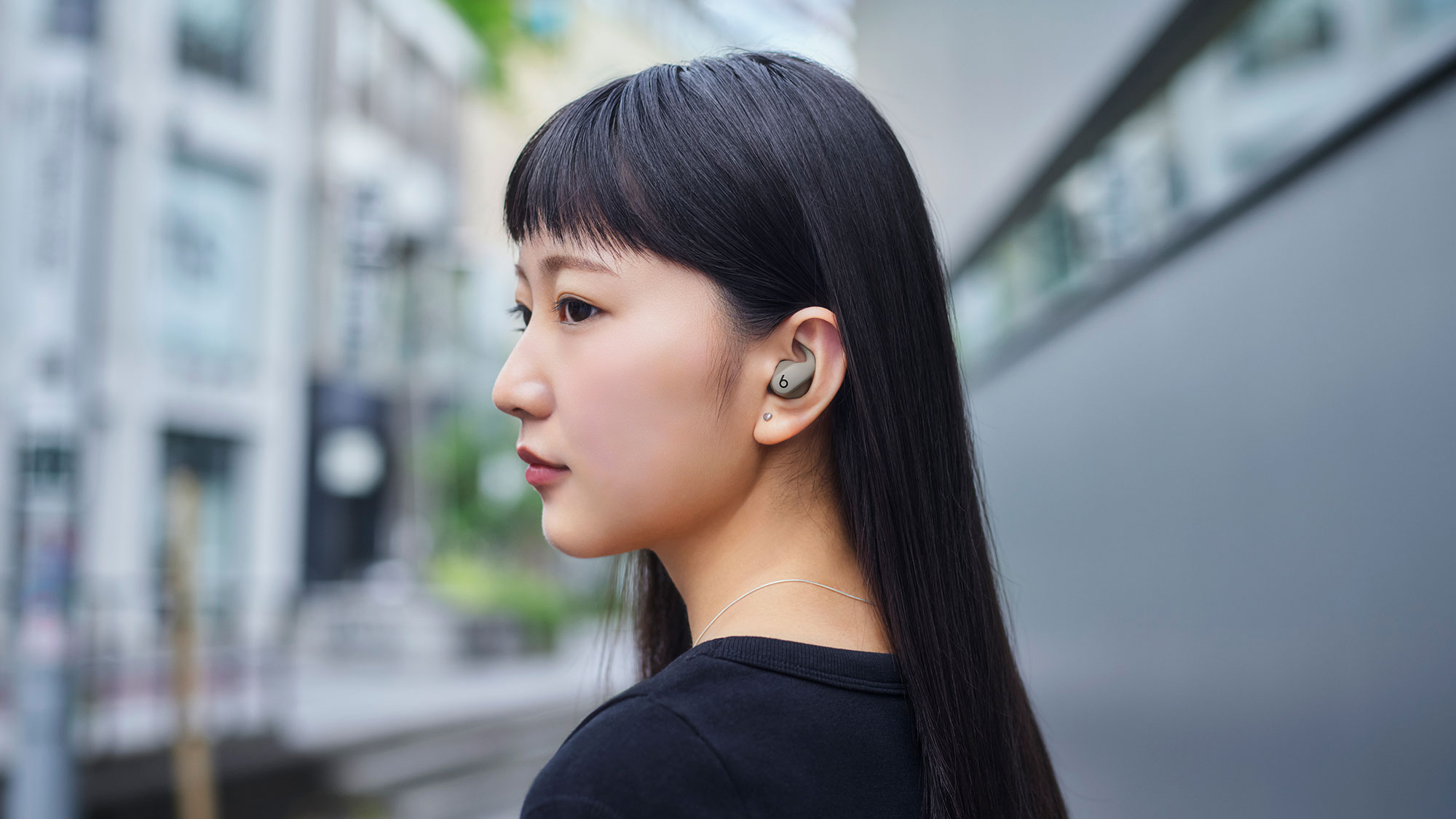 Powerbeats Fitのグラベルグレイを装着している人物