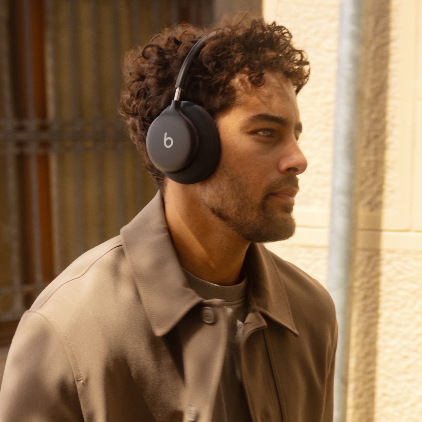 Person walking outdoors while wearing Beats 360 in Black with Black Performance Knit headband and ear cup cushions