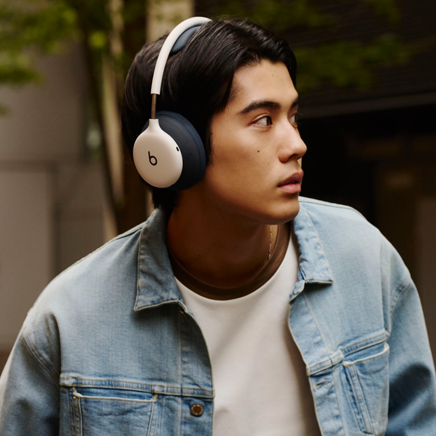 ブラックのPerformance Knitヘッドバンドクッションとイヤークッションを付けたブラックのBeats 360を装着して屋外を歩いている人物
