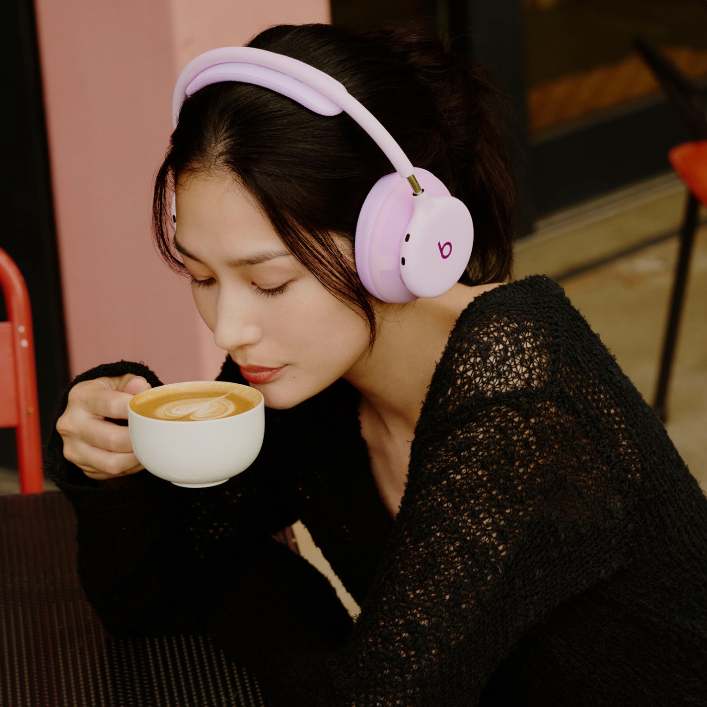 Beats 360ヘッドフォンを装着しiPhoneを持っている人物。優れた通話品質とアクティブノイズキャンセリングを示している