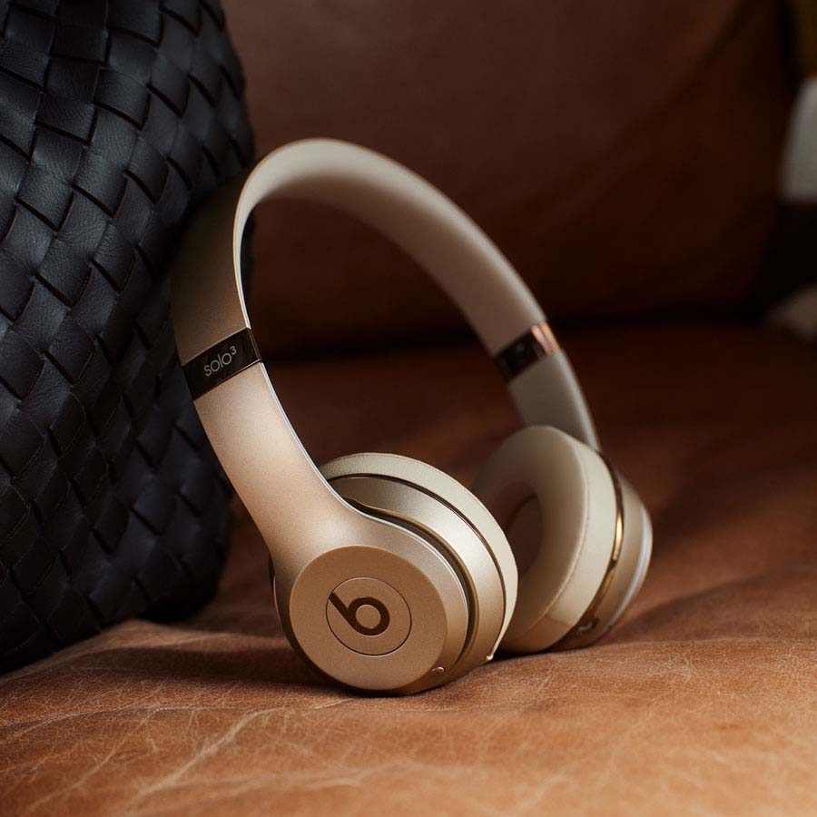 Beats Solo3 Wireless headphone in Gold laying on a table