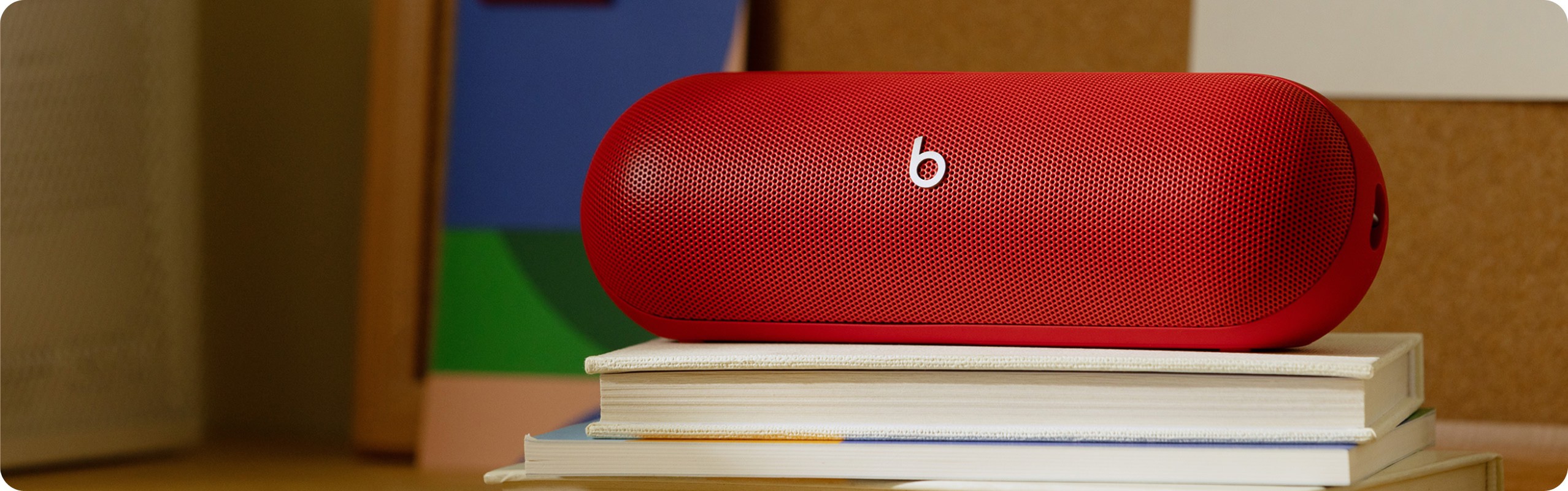 Statement Red Beats Pill speaker resting on a stack of books